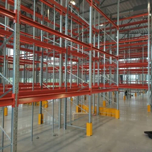 Ett system av röda och metallfärgade pallställ i en lagerlokal.