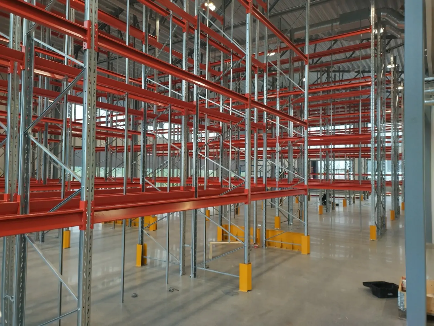 Ett system av röda och metallfärgade pallställ i en lagerlokal.